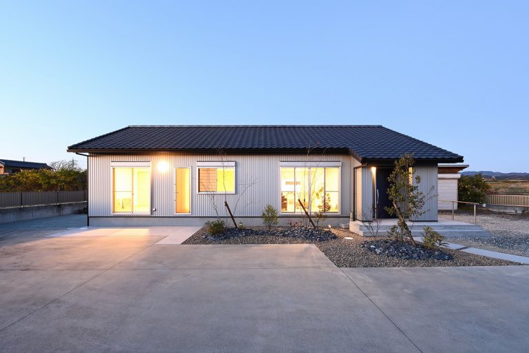 ライトグレーのガルバリウム外壁に切妻屋根を設けた平屋住宅