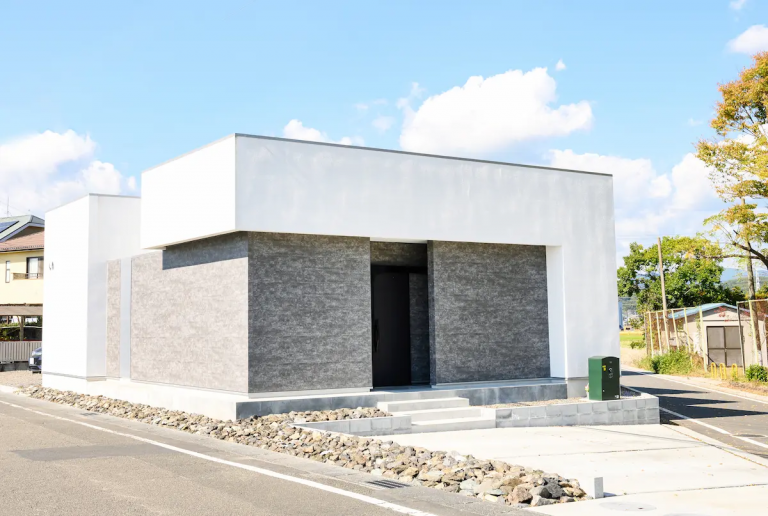 塗り壁とグレーのタイル張りが奥行を出す外観